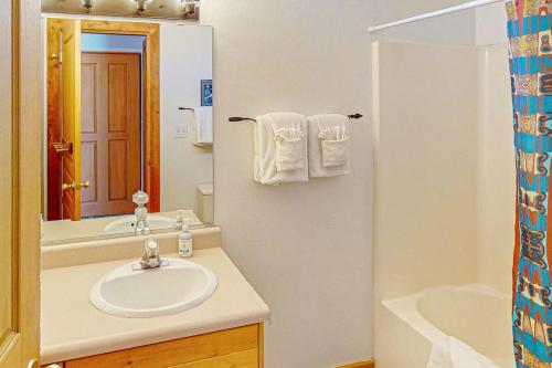 a bathroom with a sink and a mirror and a tub at Castillo De Las Rocas 3418 in Moab