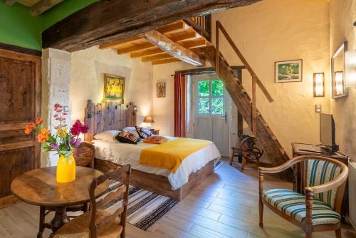 a bedroom with a bed and a table and chairs at La Maison de Yûka in Plieux