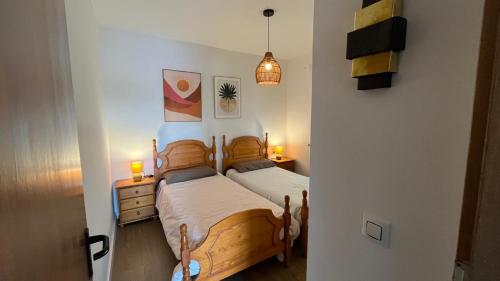 a bedroom with a wooden bed with two lamps on it at Las estrellas in Peniscola