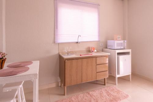 a kitchen with a sink and a microwave at Chalé Rosa - Top Country Ranch in Boituva