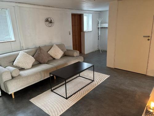 a living room with a couch and a table at Cosy Family Basement Apartment in Copenhagen Søborg with Jacuzzi in Søborg