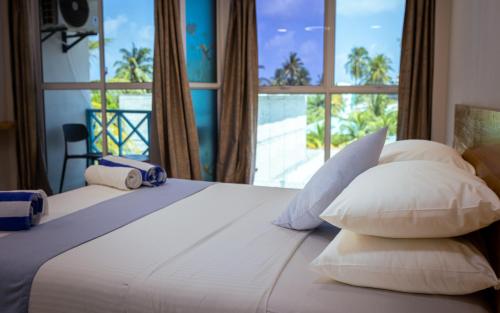 a bedroom with a bed with a large window at Buceo Inn Mathiveri in Mathiveri
