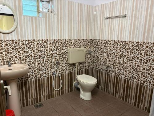 a bathroom with a toilet and a sink at Kuppath Inn in Cochin