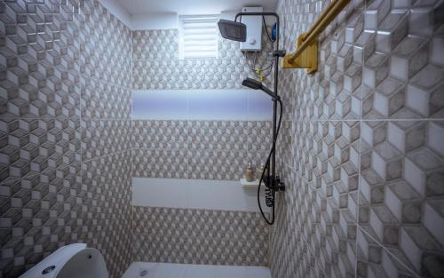 a bathroom with a shower with a toilet and a window at Buceo Inn Mathiveri in Mathiveri