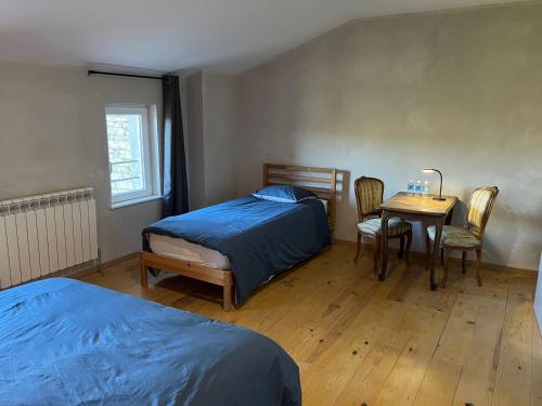 a bedroom with a bed and a table and chairs at Au point du jour Ch2 in Récourt-le-Creux