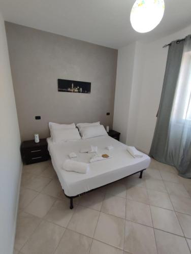 a bedroom with a white bed with white pillows at Casa Mare Relax e Cortesia in Ardea