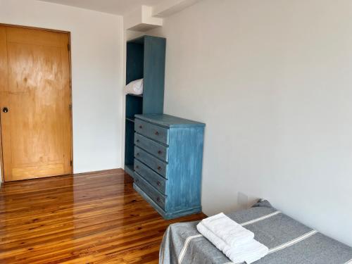 a bedroom with a blue dresser and a bed at DEPARTAMENTO dos dormitorios en Martinez, cercano a CABA, zona clinicas y oficinas, con AA y Wifi, ideal familias in Martínez