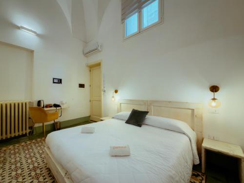 a bedroom with a large white bed with a window at Moro Guest House in Lecce