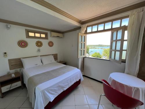 a bedroom with a bed and a desk and a window at Pousada do Mingote in Alter do Chao