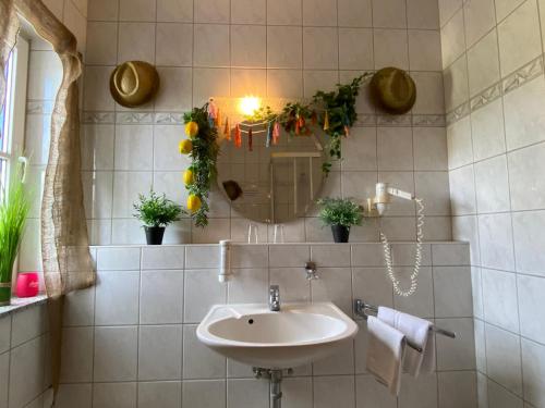 a bathroom with a sink and a mirror with plants at Seehof Hotel am Aartalsee in Bischoffen
