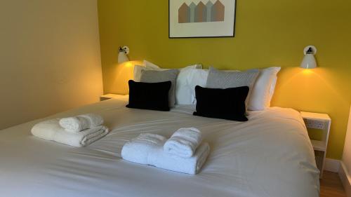 a white bed with towels on top of it at Findochty - 2 Bed Luxury Apartment by Together Travel in Wick