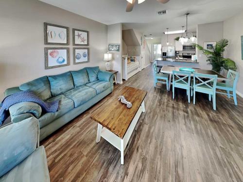 a living room with a blue couch and a table at Trestles in Padre Island