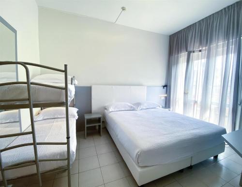 a bedroom with two bunk beds and a window at Hotel Aron Rimini in Rimini
