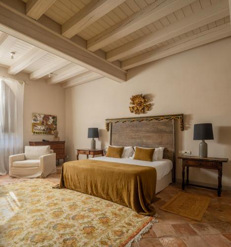 a bedroom with a large bed and a couch at Hotel Finca El Peregrino in Puente la Reina