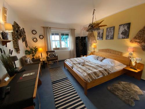 a bedroom with a large bed and a desk at Seehof Hotel am Aartalsee in Bischoffen