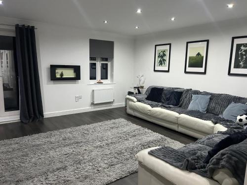 a living room with a couch and a rug at Entire 3 bedroom deluxe house in Cleckheaton
