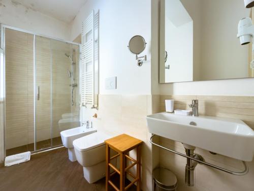 a bathroom with a sink and a toilet and a mirror at Moro Guest House in Lecce