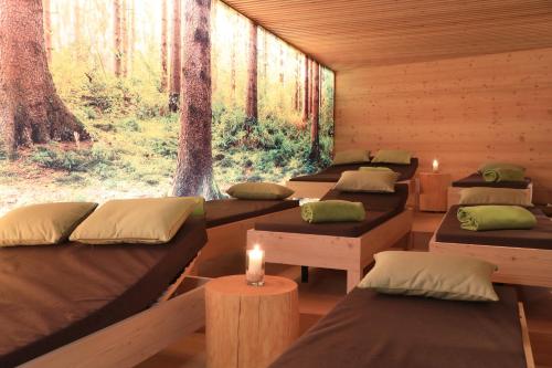 a row of beds in a room with trees at Hotel Weiler - Aktiv & Tradition in Obertilliach