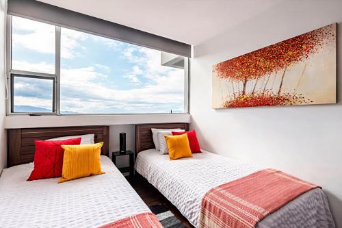 two beds in a room with two windows at Torre Ambar Executive Residences in San José