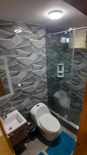 a bathroom with a toilet and a shower and a sink at El Encanto in Duitama