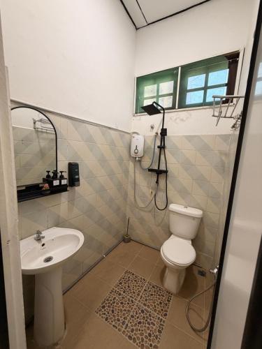 a bathroom with a toilet and a sink at NorvillaB Pantai Cenang in Pantai Cenang