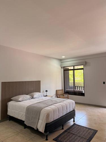 a bedroom with a large bed and a window at Guayacan Real Deluxe in Nicoya