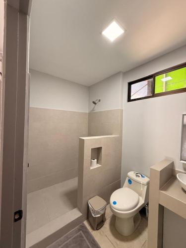 a bathroom with a toilet and a sink at Guayacan Real Deluxe in Nicoya