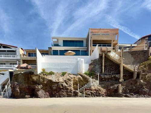 a building on top of a cliff next to a beach at San Antonio Del Mar - Beachfront Studio for Two in San Antonio del Mar