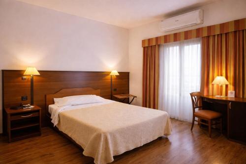 a hotel room with a bed and a desk at Hotel Bel Sit in Comerio