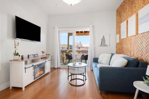 a living room with a blue couch and a tv at Jennifer's Chic Downtown City Views Private Deck in Providence