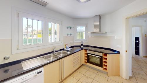 a kitchen with a sink and two windows at Greenview Villa by ON Travel in Oliva