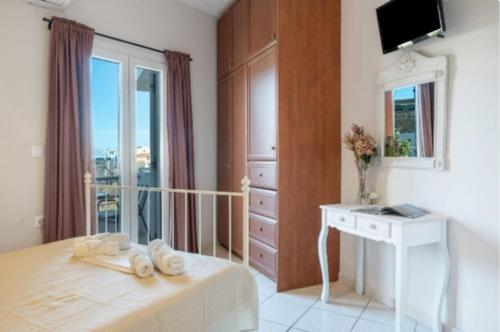 a bedroom with a bed and a desk and a window at Katerina Irida in Mérikhas