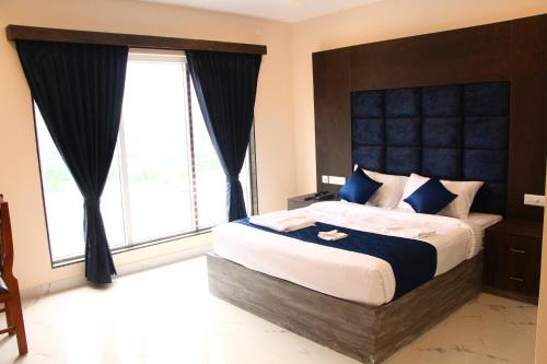 a bedroom with a large bed with a large window at sas square hotels in Tiruchirappalli