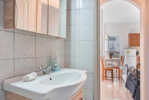 a bathroom with a white sink and a kitchen at Katerina Irida in Mérikhas