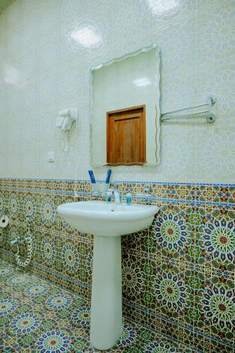 a bathroom with a sink and a mirror at Imperial Palace Bukhara in Bukhara