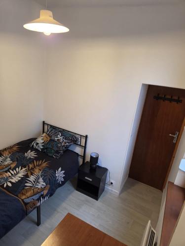 a bedroom with a bed and a wooden door at Appartement Le Gwen - Centre Ville de Givet in Givet