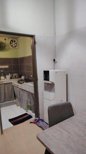 a kitchen with a white refrigerator and a table at MQ Homestay in Temerloh