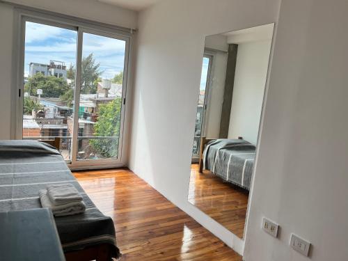 a bedroom with two beds and a mirror at DEPARTAMENTO dos dormitorios en Martinez, cercano a CABA, zona clinicas y oficinas, con AA y Wifi, ideal familias in Martínez
