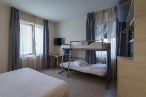a bedroom with two bunk beds and a window at Albergo Morgana in Mendrisio