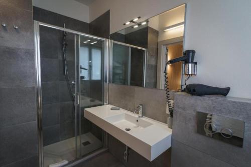 a bathroom with a sink and a shower at Albergo Morgana in Mendrisio