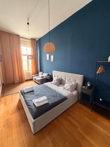 a bedroom with a bed and a blue wall at Blue Velvet Central Suite in Arad
