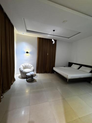a room with a bed and a chair in it at U&U place in Uyo