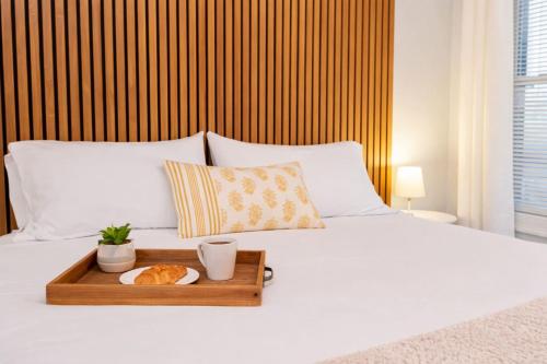 a bed with a tray with a cat on it at Jennifer's Getaway Stunning Views & Private Deck in Providence