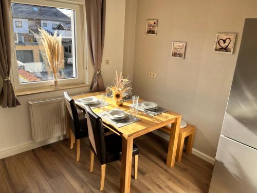 a wooden dining room table with chairs and a window at Ferienwohnung Erhol Dich Gut in Diez