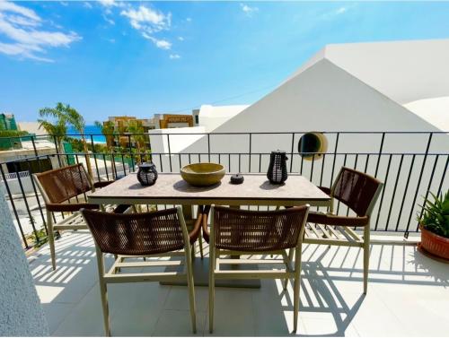 a table and chairs on a balcony with a view of the ocean at Santorini Village, Drymades, Dhermi in Dhërmi