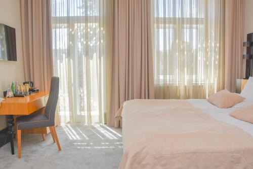 a hotel room with a bed and a desk and window at Hotel Nihil Novi in Radom