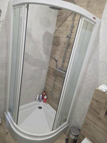 a shower with a glass door in a bathroom at Apartament M&G in Jarosław