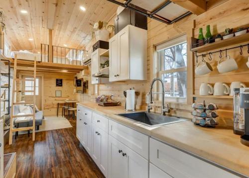 a kitchen with white cabinets and a sink at Red Rock Roost Posh Studio near Hiking Trails in Colorado Springs