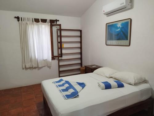 a bedroom with a bed with blue and white pillows at Habitacion Sol in Puerto Escondido