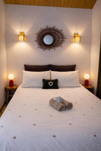 a bedroom with a white bed with a mirror on the wall at Un Chalet au Verger-Dog friendly-Jacuzzi & Massages in Conteville